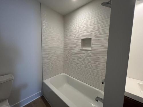 a white bathroom with a tub and a toilet at Agresti Mil in Brant Beach