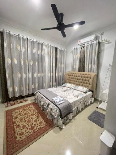 - une chambre avec un lit et un ventilateur de plafond dans l'établissement D'S WHITE VILLA HOMESTAY @ UITM MACHANG, 