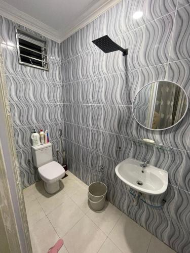 La salle de bains est pourvue d'un lavabo, de toilettes et d'un miroir. dans l'établissement D'S WHITE VILLA HOMESTAY @ UITM MACHANG, 