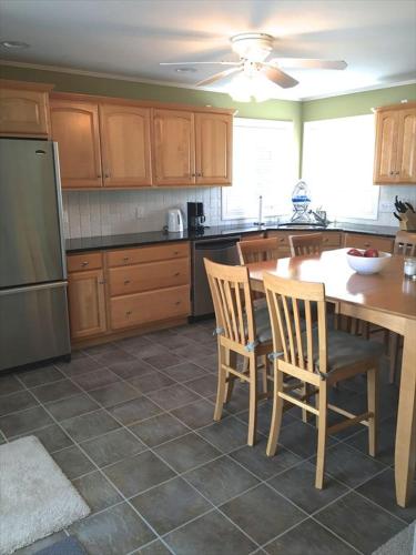 a kitchen with a table and chairs and a refrigerator at Clemente 1 in Brant Beach