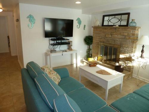 ein Wohnzimmer mit einer blauen Couch und einem Kamin in der Unterkunft Oceanside 3 Bedroom, 1 Bath Duplex - A Short Walk To The Beach! in Beach Haven Crest