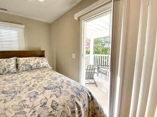 a bedroom with a bed and a sliding glass door at Family Friendly Vacation Rental On Lbi in Beach Haven
