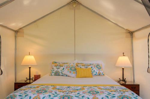 a bedroom with a white bed with two lamps at Beautiful cozy tent in Catskill in Catskill