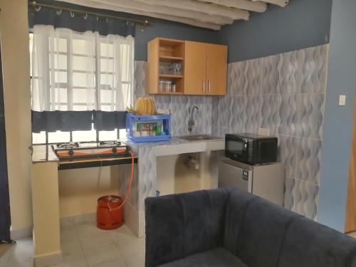 a kitchen with a sink and a microwave at MAGNOLIA SUITES in Ukunda