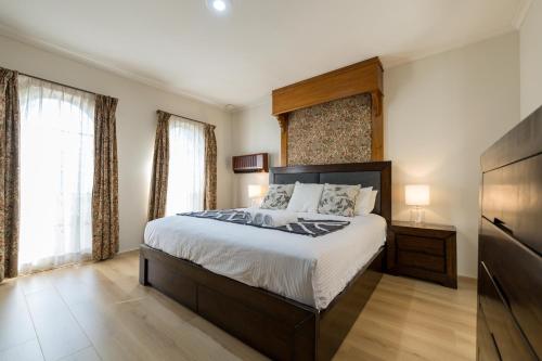 1 dormitorio con 1 cama grande y TV en Cheerful 4-bedroom home with Park View, en Glen Waverley