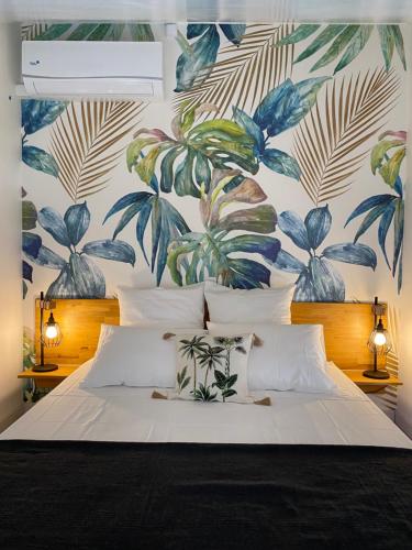 - une chambre avec un grand lit et du papier peint floral dans l'établissement La Réunion Plein la Vue, à Saint-Paul