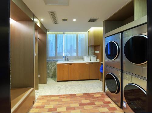 a laundry room with a washer and dryer at Maison New Century Tongxiang in Tongxiang
