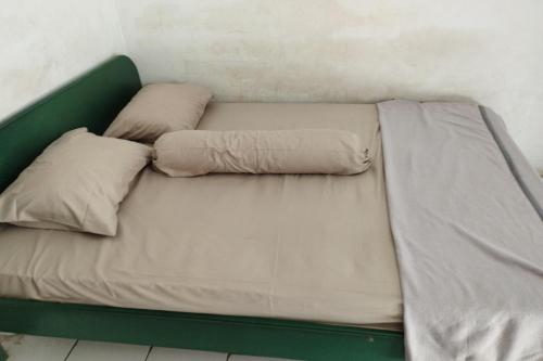 ein Bett mit zwei Kissen auf einem Zimmer in der Unterkunft SPOT ON 93534 Losmen Karunia Katingan 