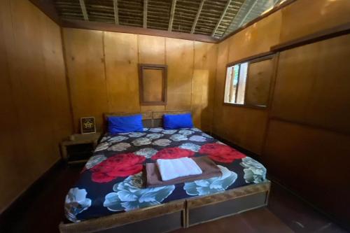 a small bedroom with a bed with blue pillows at SPOT ON 93511 Rinjana Homestay in Tanjung