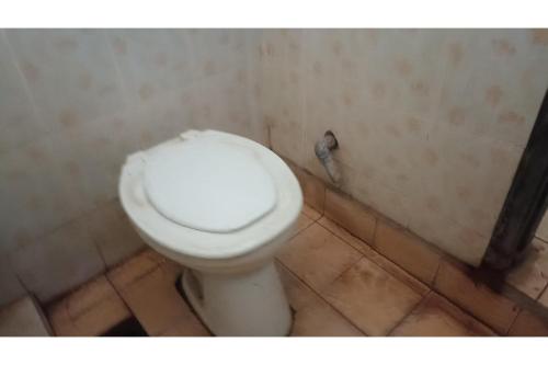 uma casa de banho com um WC branco num quarto em SPOT ON 93524 Bagas Homestay em Lembuak