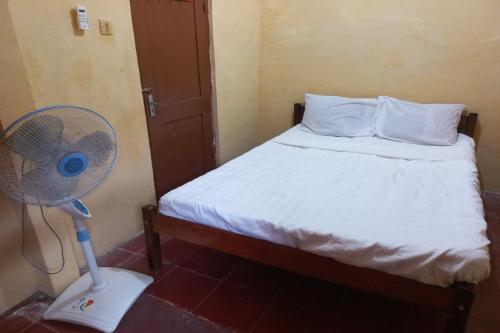 - une chambre avec un lit et un ventilateur dans l'établissement SPOT ON 93539 Juan Guest House, à Purwokerto