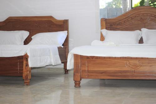 2 camas con almohadas blancas y almohadas mullidas en Faradel Motel en Fomboni