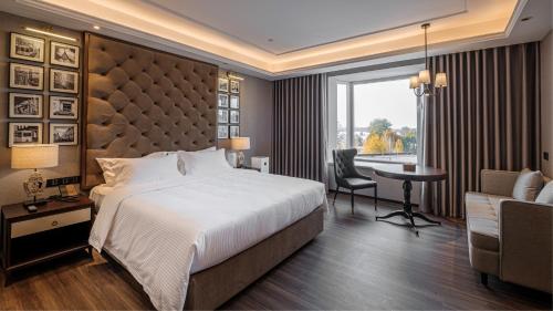 a hotel room with a large bed and a desk and a desk at Moon River Puyue Hotel in Beijing