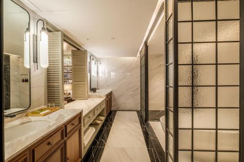 a bathroom with a sink and a shower at Moon River Puyue Hotel in Beijing