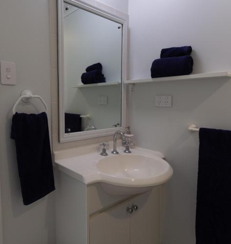 a bathroom with a sink and a mirror and towels at Bella Vista - Spectacular Ocean Views & Continental Breakfast in Yeppoon