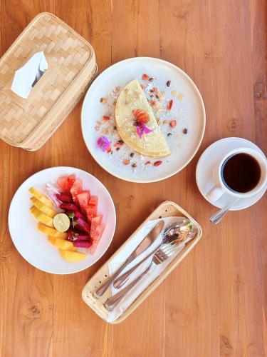 un tavolo con piatti di cibo e una tazza di caffè di Uma Raos Cottage ad Ubud