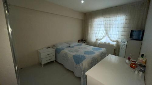 Dormitorio pequeño con cama y lavamanos en Konuk evi en Yenimahalle