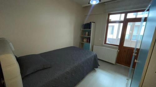 um pequeno quarto com uma cama e uma janela em Konuk evi em Yenimahalle