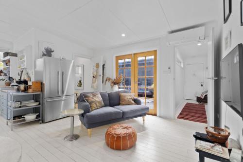 a living room with a couch and a refrigerator at Adrift - Pet-friendly - 5 min Walk to Bay - Rustic Charm in Erowal Bay