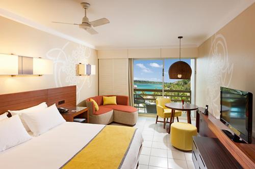 um quarto de hotel com uma cama e uma sala de estar em Holiday Inn Resort Vanuatu, an IHG Hotel em Port Vila