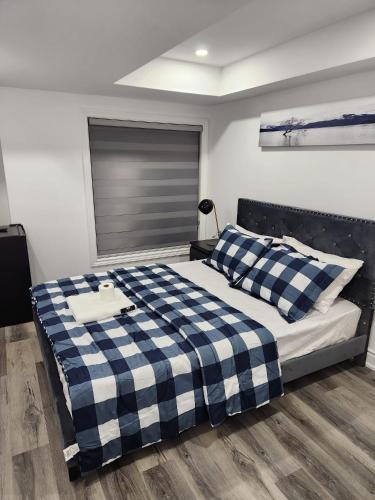 InnisfilにあるNew Modern room in Innisfilのベッドルーム(青と白のチェッカーベッド付)