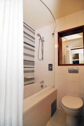 a bathroom with a tub and a toilet and a sink at Holiday Inn Resort Vanuatu by IHG in Port Vila