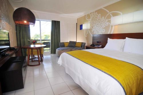 a hotel room with a large bed and a television at Holiday Inn Resort Vanuatu by IHG in Port Vila