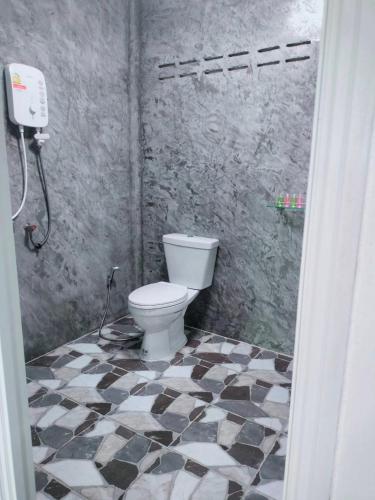 a bathroom with a toilet and a black and white tiled floor at Baan Namthip Homestay Trang บ้านน้าทิพย์ โฮมสเตย์ตรัง in Ban Huai To (1)