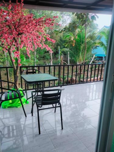 a patio with a table and chairs and a tree at Baan Namthip Homestay Trang บ้านน้าทิพย์ โฮมสเตย์ตรัง in Ban Huai To (1)