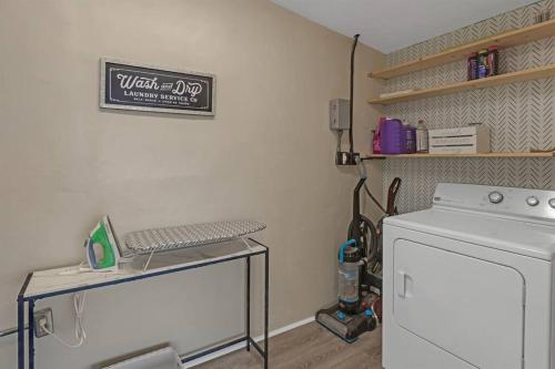 a laundry room with a stove and a table with a washing machine at 7-Person Luxury Spa, Fenced Paradise, Beach Vibes in Pembroke Pines