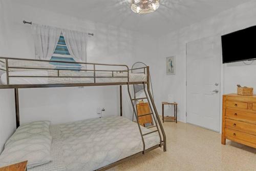 1 dormitorio con litera, TV y tocador en 7-Person Luxury Spa, Fenced Paradise, Beach Vibes, en Pembroke Pines