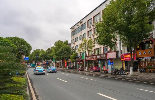 a city street with cars driving down the street at 张家界大庸家民宿天门山索道站店DYJ Residential hostel in Zhangjiajie
