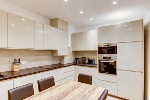 une cuisine avec des armoires blanches et une table en bois dans l'établissement Old Town Nice, very near Beach, à Nice