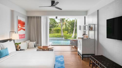 een slaapkamer met een bed en een woonkamer met een zwembad bij Kimpton Kitalay Samui, an IHG Hotel in Choeng Mon Beach