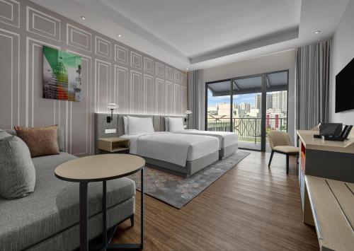 a hotel room with a bed and a couch at Hyatt Place Kuala Lumpur Bukit Jalil in Kuala Lumpur