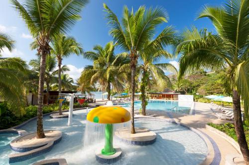 a pool with a water park with palm trees at Holiday Inn Resort Vanuatu by IHG in Port Vila