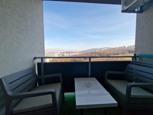 a balcony with two chairs and a table and a view at Gray apartment nearby Amethyst & Vivo Mall in Floreşti