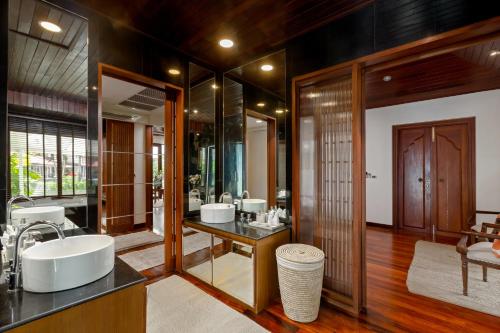 a bathroom with three sinks and a large mirror at Surin Lake Villa in Surin Beach