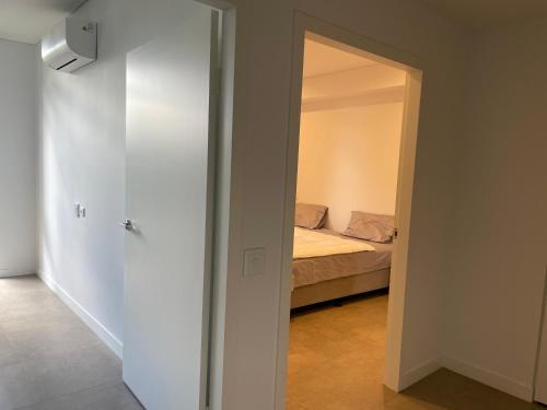 a room with a bed and a door to a bedroom at Unit 103, 1-5 Oxford Street, Blacktown, NSW 2148 in Blacktown