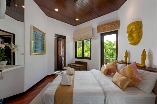 a bedroom with a large white bed in a room at Surin Lake Villa in Surin Beach