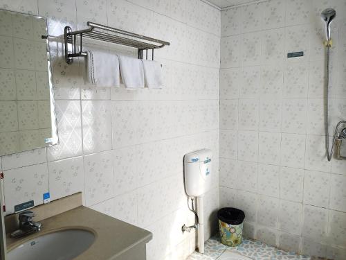 uma casa de banho com lavatório, espelho e toalhas em 张家界大庸家民宿DYJ Hostel em Zhangjiajie