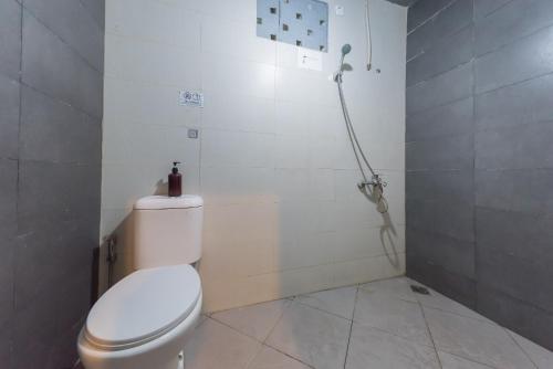 a bathroom with a toilet and a shower at Urbanview Hotel Cianjur City Park by RedDoorz in Tjiandjur