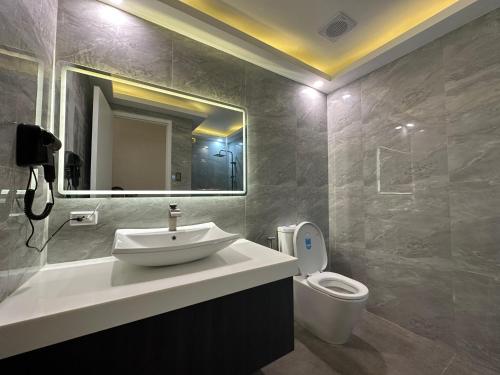 a bathroom with a sink and a toilet at The Beach Suites at Pico De Loro in Nasugbu