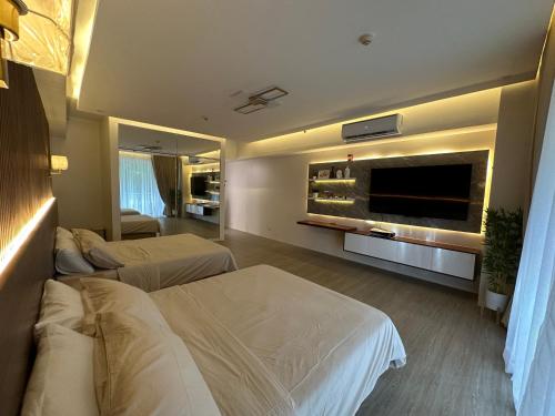 Habitación de hotel con 2 camas y TV de pantalla plana. en The Beach Suites at Pico De Loro en Nasugbu
