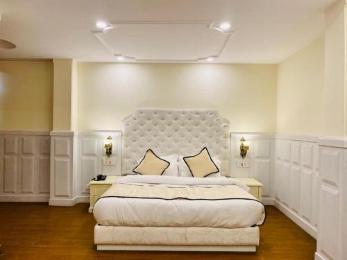 1 dormitorio con 1 cama grande y cabecero blanco en Taarra view green with parking en Gangtok