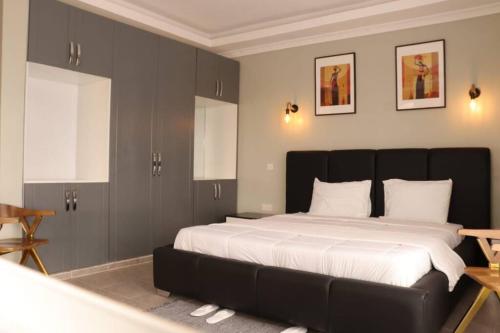 a bedroom with a large bed with a black headboard at Enkai Farmhouse near Ol-Pejeta Nanyuki in Nanyuki