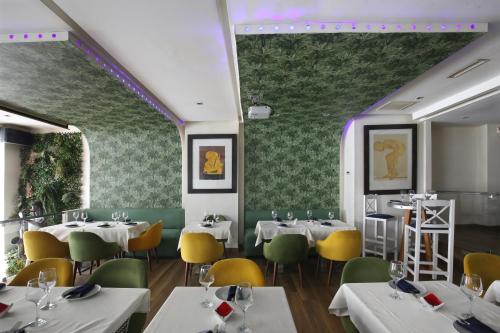 un ristorante con tavoli bianchi e sedie gialle di Park Suites Hotel & Spa Luxury Boutique Hotel a Casablanca