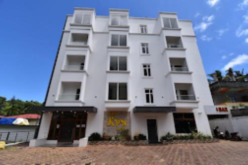 a white building with windows on the side of it at Hotel SRI KPN , Austinabad in Austinābād