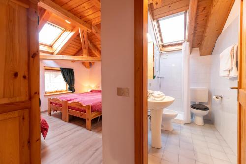 a bedroom with a bed and a sink and a toilet at Agritur B&B Iellici in Castello di Fiemme