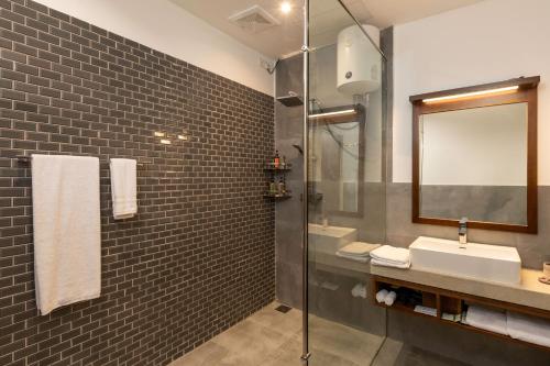 a bathroom with a shower and a sink and a mirror at Vis Ta Vie -Thema Collection in Mirissa